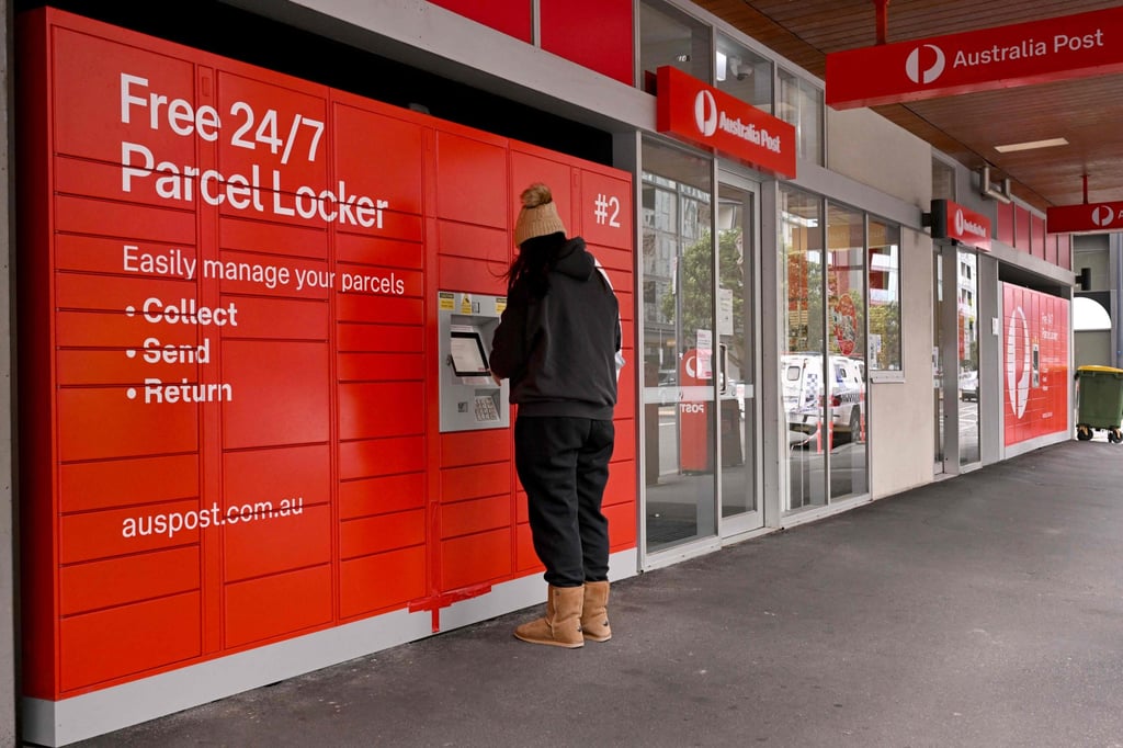 A customer collects a parcel at an Australia Post store in Melbourne on August 26. Australia has joined a string of countries suspending some postal deliveries to the United States. Photo: AFP