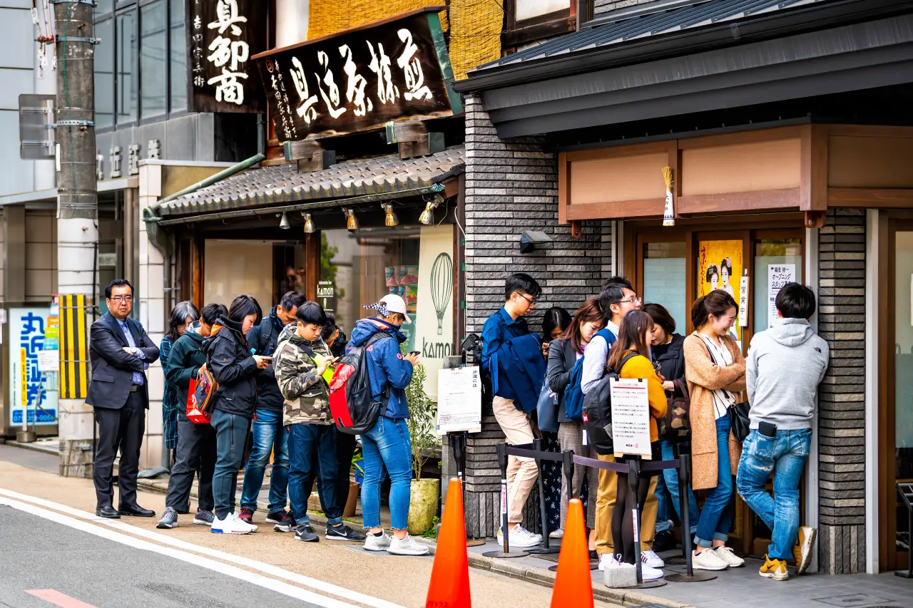 People waiting in line outside Teramachi Fukuda restaurant near Nishiki Market in Kyoto, Japan, for traditional kaiseki cuisine. 