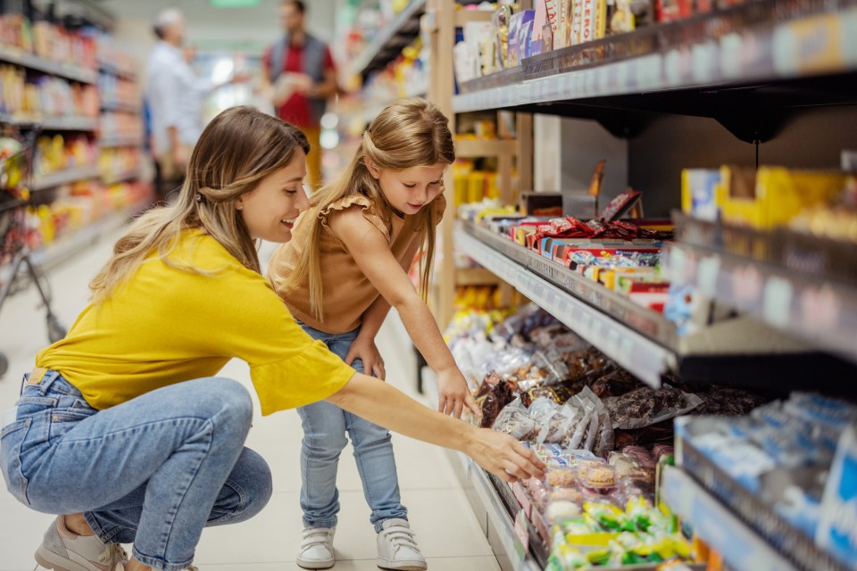 A mother and daughter shopping for groceries in a supermarket.