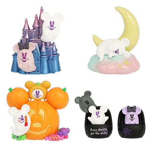 Four ghost-shaped figurines from the 2025 Halloween Merchandise interact with a castle, moon, pumpkin, & gravestones.