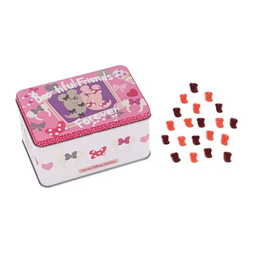 A pink tin box from Tokyo Disney Resort 2025 Halloween Merchandise with cartoon dogs, beside red and orange gummy bears.
