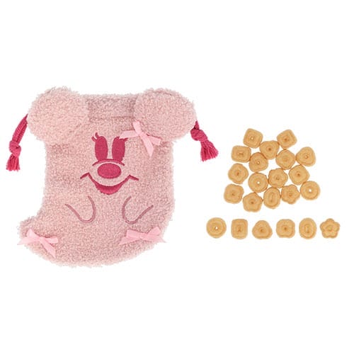 Pink fuzzy bear pouch with bows from Tokyo Disney Resort, next to tan snacks—cute 2025 Halloween merchandise.