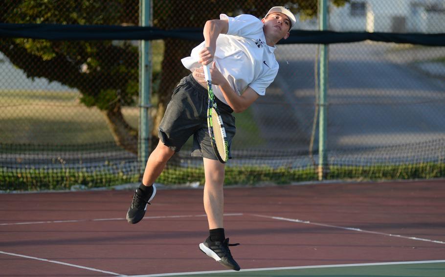 Maddux Fisk follows through after a serve.