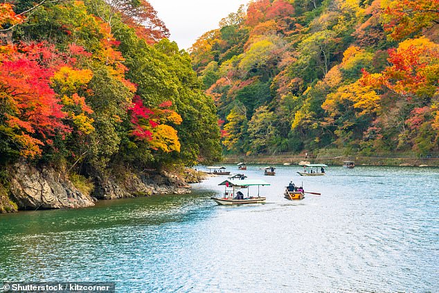 Pictured: Tourists take a boat trip at Arashiyama in Kyoto, Japan
