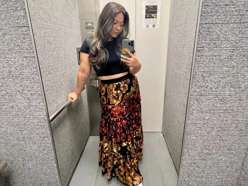 Author Ashley Probst taking mirror selfie in elevator wearing colorful skirt