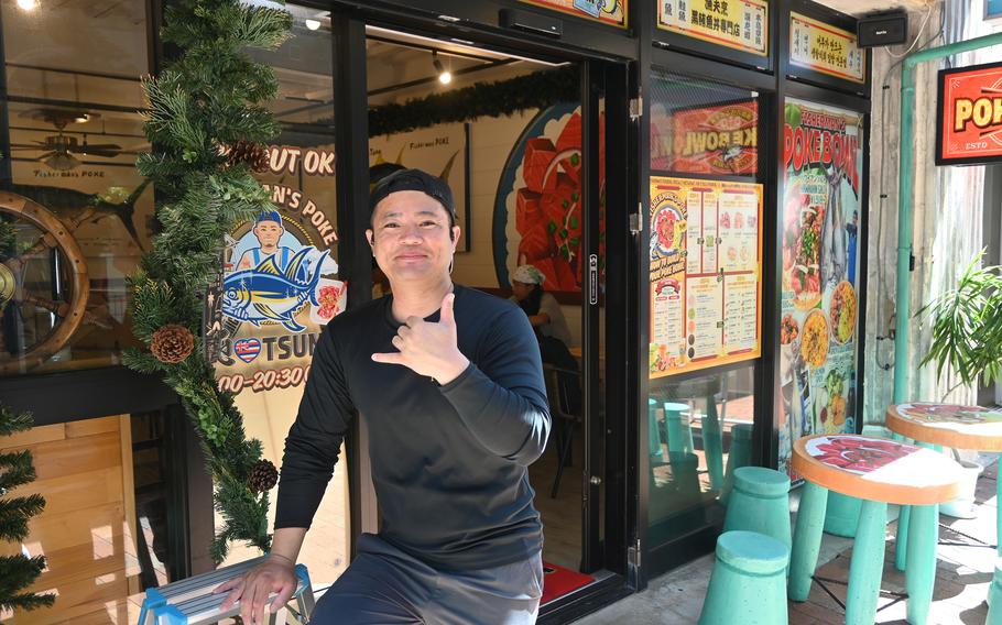 A man poses outside a restaurant.