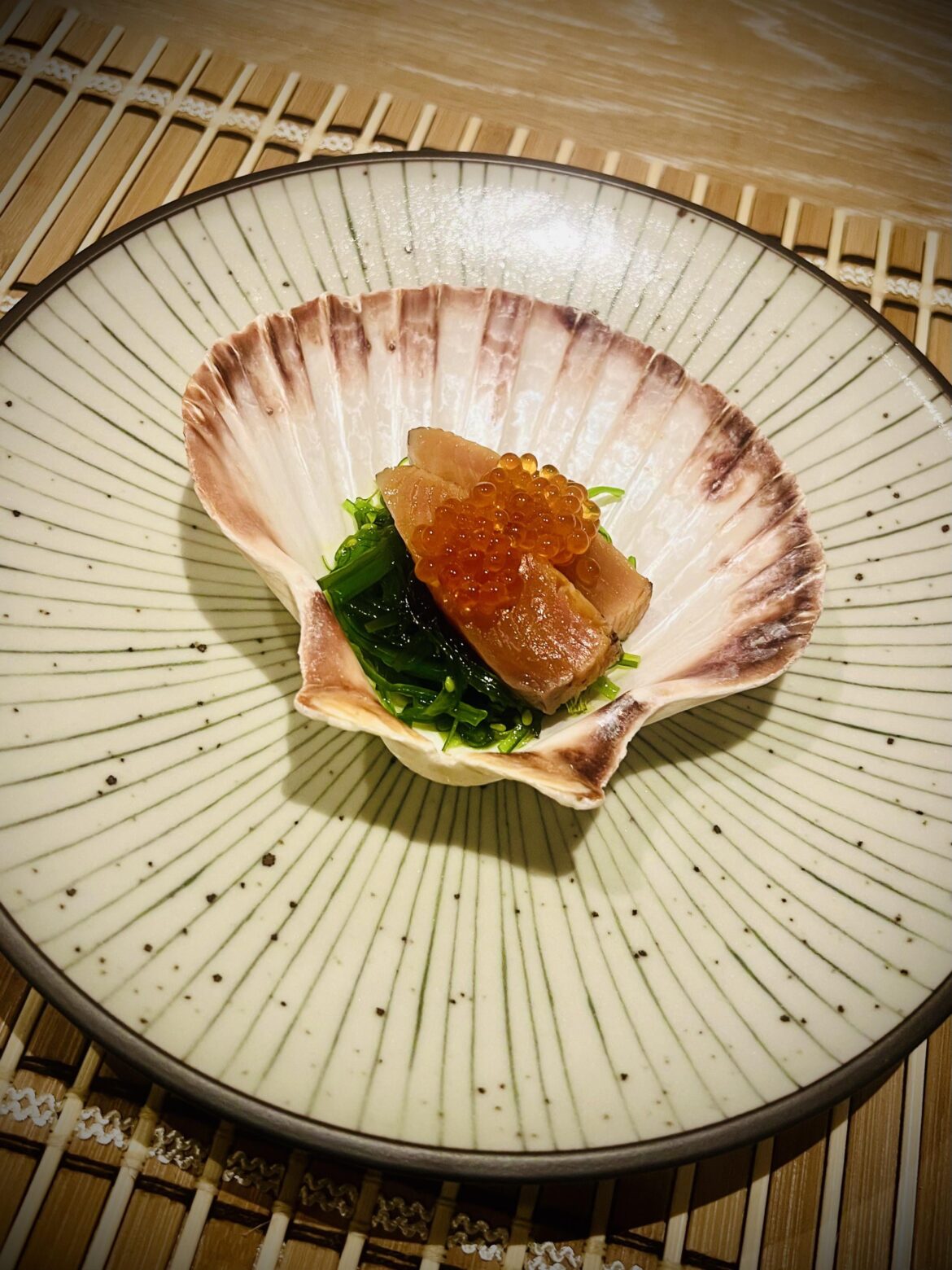 Seared salmon and ikura on a bed of seasoned seaweed