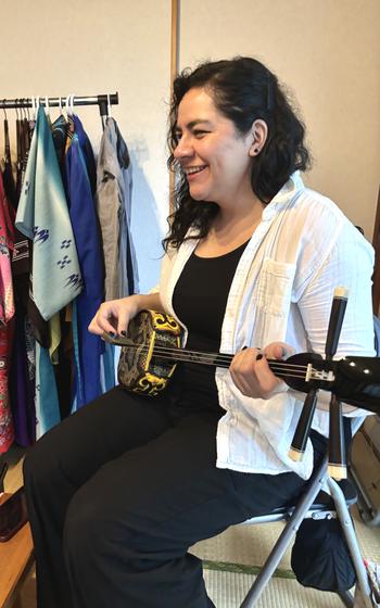 Denisse plays the sanshin.