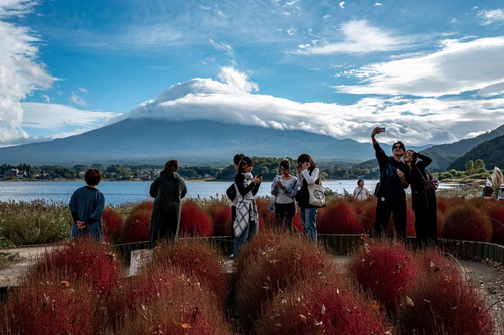 Tourists take pictures as cloud-clad Mount Fuji is seen in the background from Oishi park in the town of Fujikawaguchiko, Yamanashi prefecture, Japan, on Saturday. Photo: AFP Tourists take pictures as cloud-clad Mount Fuji is seen in the background from Oishi park in the town of Fujikawaguchiko, Yamanashi prefecture, Japan, on Saturday. Photo: AFP