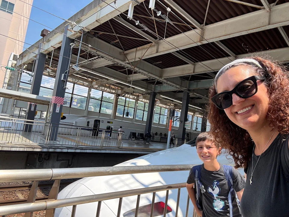 Mom and son posing with a train in Japan