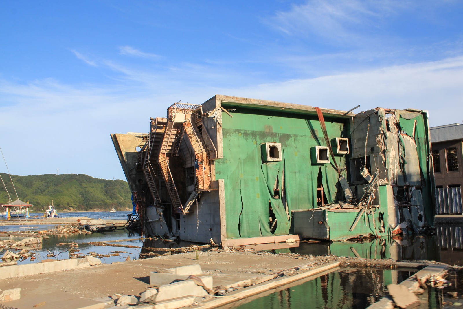 Building with green roof lies on its side in Onagawa after the tsunami of 2011