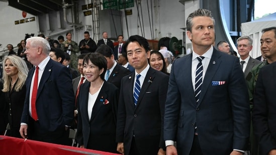 US Ambassador to Japan George Glass (2nd L), Japan's Prime Minister Sanae Takaichi (3rd L), Japan's Defense Minister Shinjiro Koizumi (2nd R), and US Defense Secretary Pete Hegseth (R) react to US President Donald Trump's speech in front of US Navy personnel on board the US Navy's USS George Washington aircraft carrier at the US naval base in Yokosuka on October 28, 2025. (Photo by ANDREW CABALLERO-REYNOLDS / AFP)(AFP)