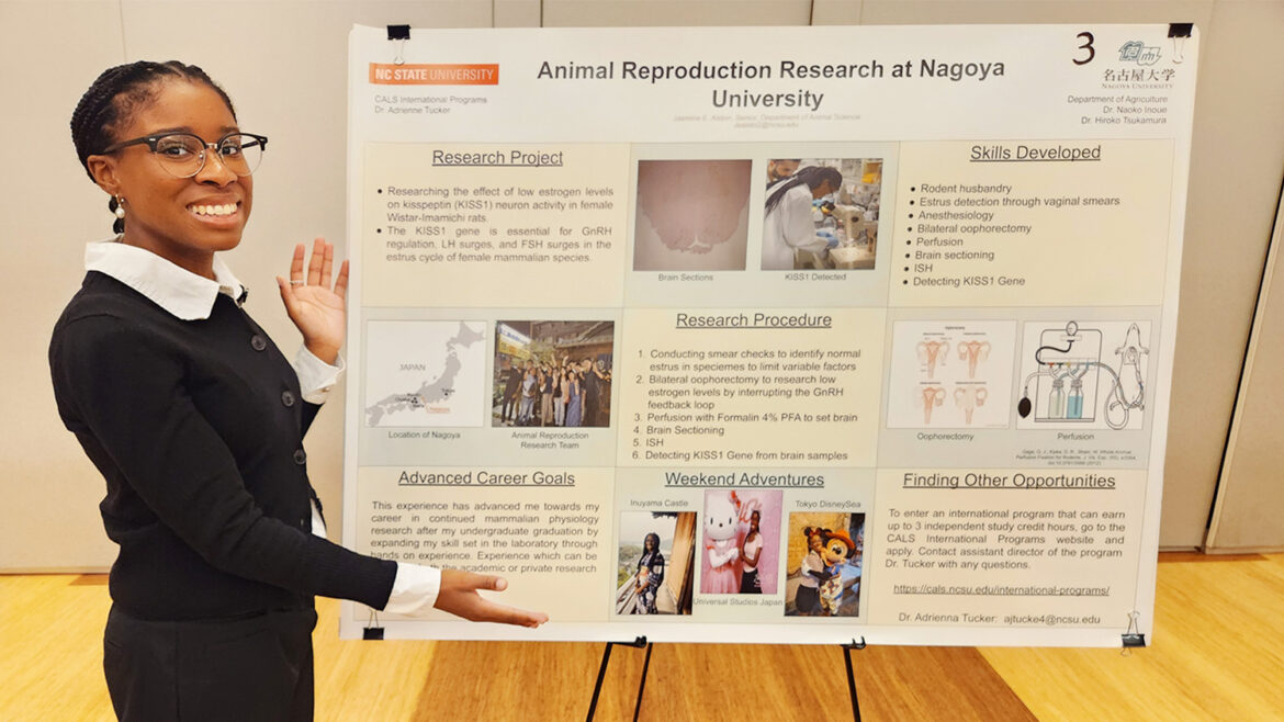 Young woman standing in front of a science poster