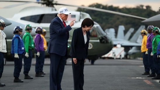 Trump gestures next to Japanese Prime Minister Sanae Takaichi as they are welcomed by U.S. Navy Rainbow Side Boys, aboard the aircraft carrier USS George Washington, during a visit to U.S. Navy's Yokosuka base in Yokosuka, Japan, October 28, 2025. REUTERS/Evelyn Hockstein(REUTERS)