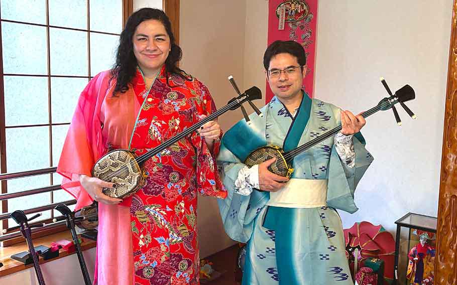 Dennise and Shoji pose for a photo with sanshin.