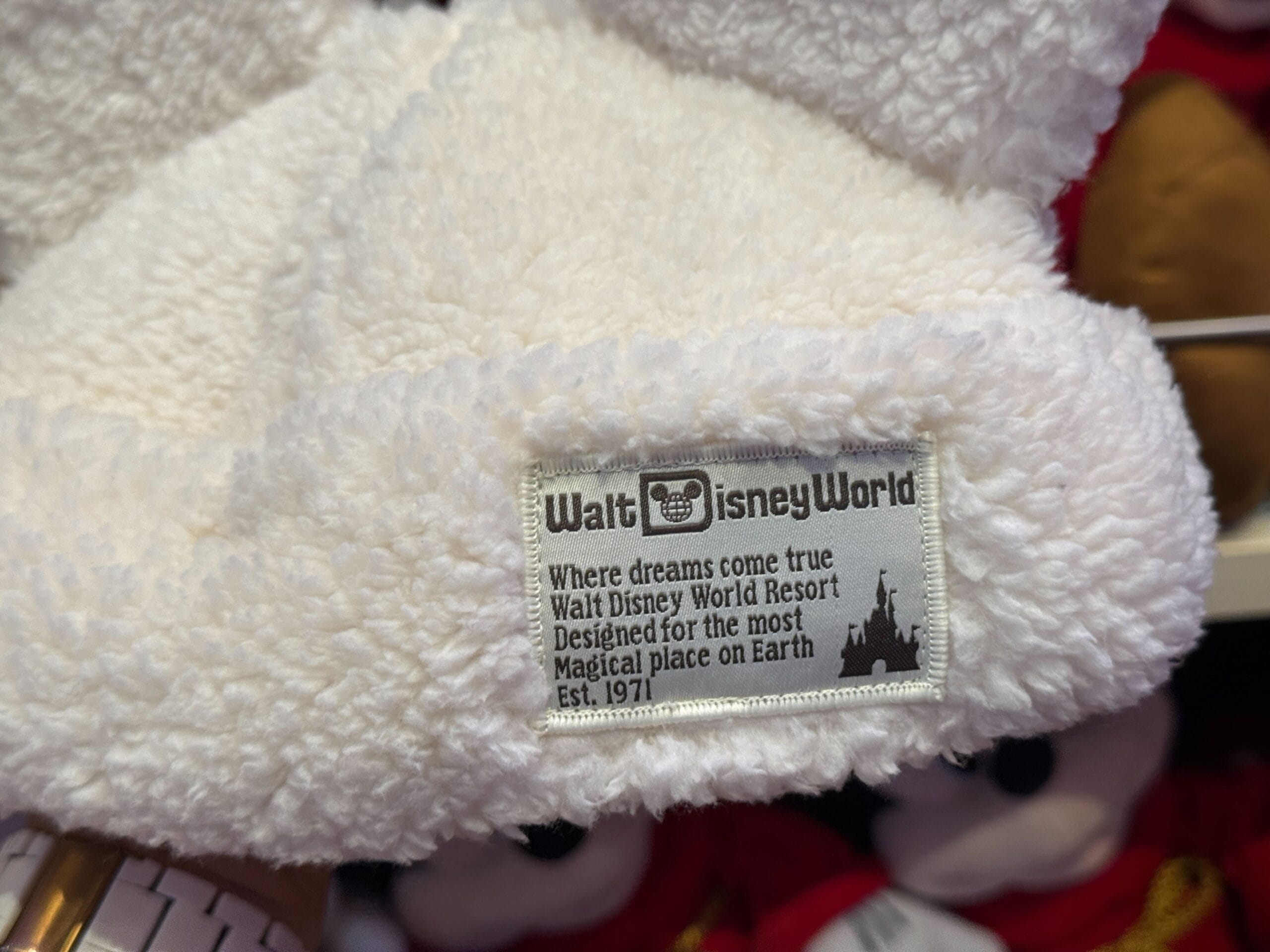 A white fuzzy Winter Cap with a Walt Disney World label, celebrating "the most Magical place on Earth.