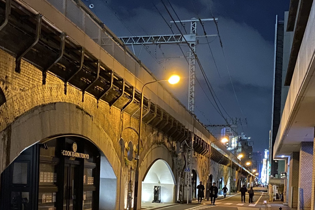 People walk along a street parallel to train tracks built for the Yamanote and other lines in Tokyo. (Photo: Saritdet Marukatat)