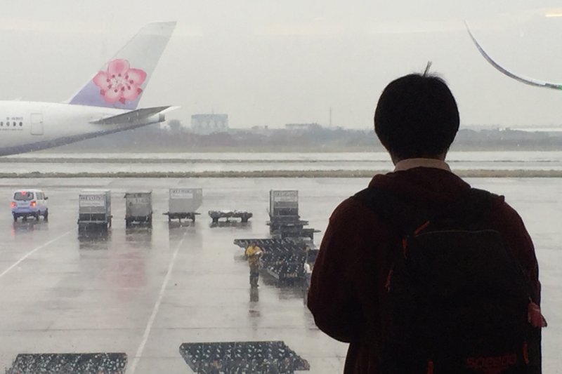 A passenger watches a China Airlines plane parked at Narita airport near Tokyo. (Photo: Saritdet Marukatat)