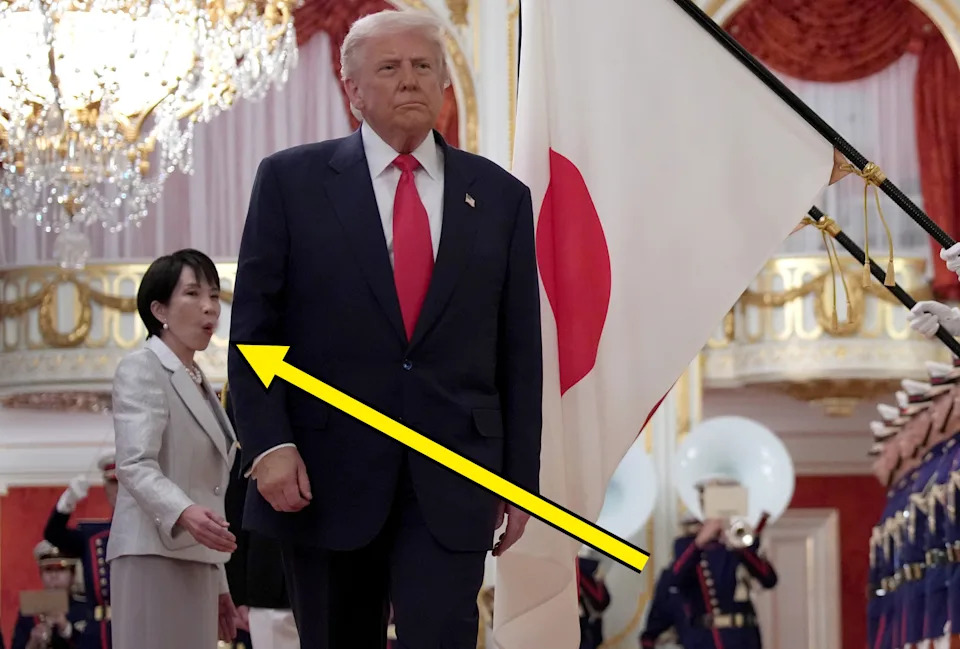 A person in a suit walks past an honor guard inside an ornate room, accompanied by another individual in formal attire