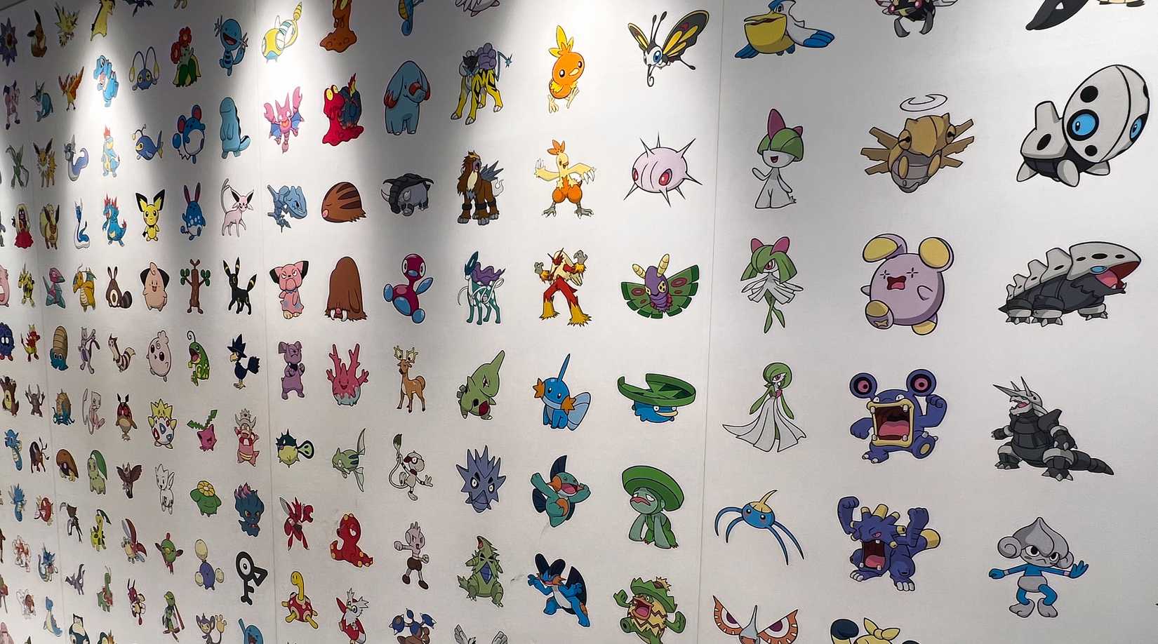 a mural featuring the first three generations of pokemon on a wall.