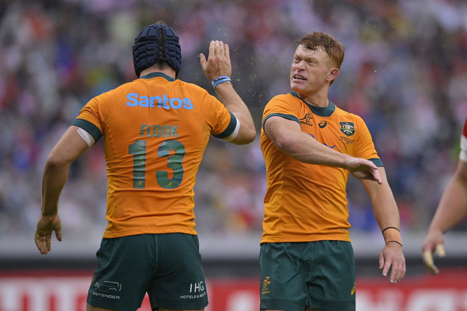 Wallabies players high-five each other.
