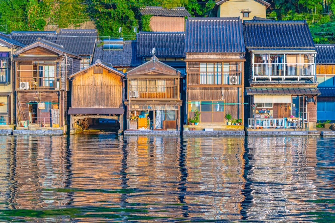 Ine, Kyoto. A line of houses on the waterfront with their reflections shimmering in the water below