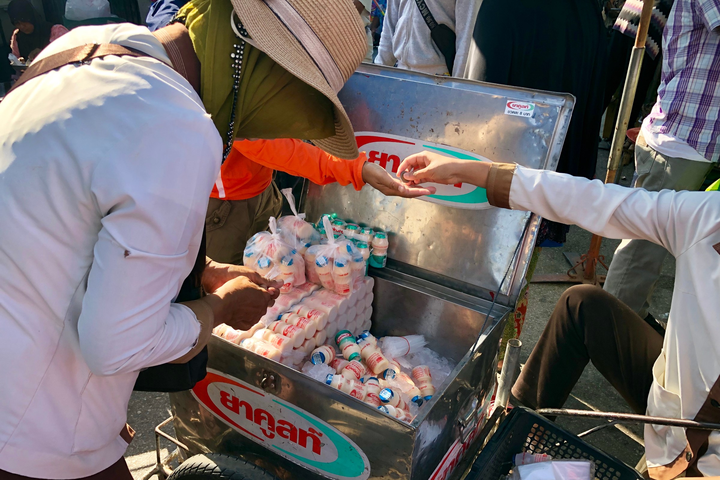 A Yakult lady sells drinks on the street in Thailand.