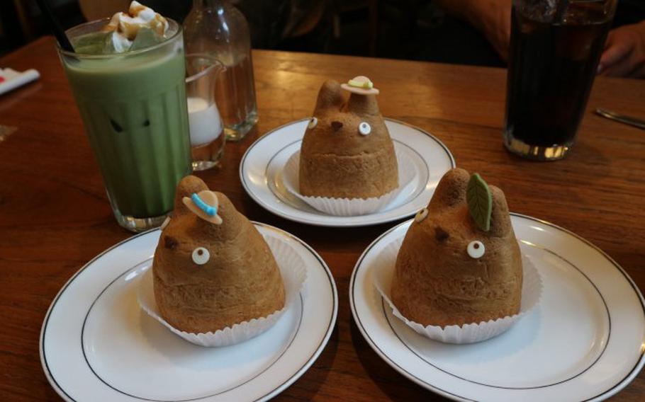 Three Totoro cream puffs and three glasses of beverages on the table.