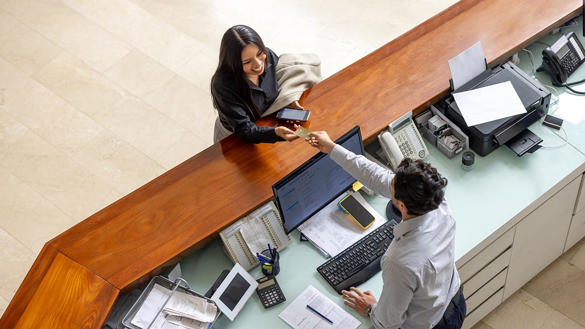 Woman traveling checking in at desk.