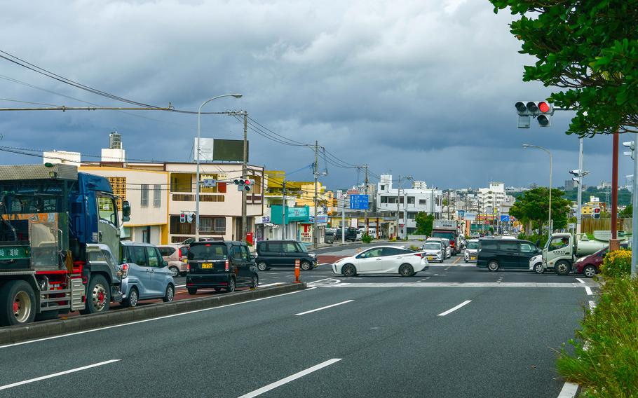 Vehicles line a street in Okinawa, Japan.