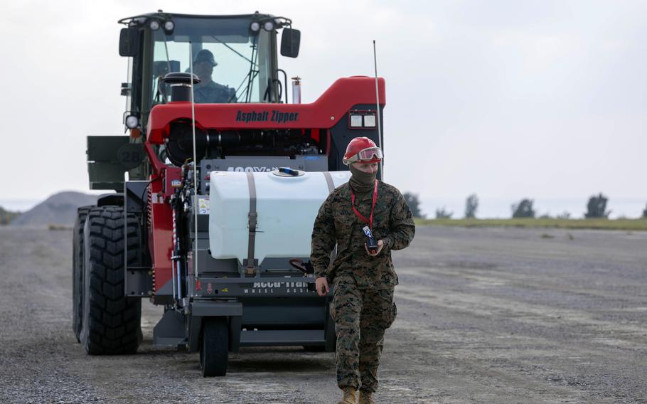 A Marine walks in front of a vehicle in Okinawa, Japan