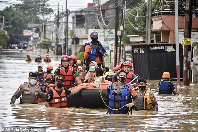 Rescuers evacuate residents from their flooded homes in Bekasi on February 19, 2021, as heavy rain inundated the city on the outskirts of Jakarta