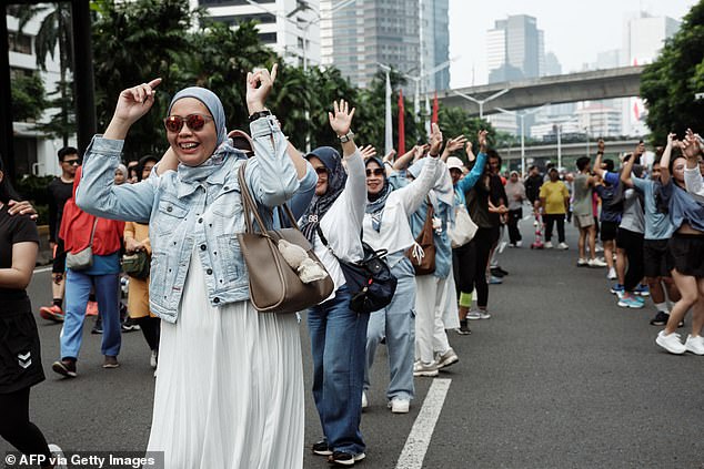 People take part in a free Zumba dance workshop on a street during Car Free Day in Jakarta on August 24, 2025