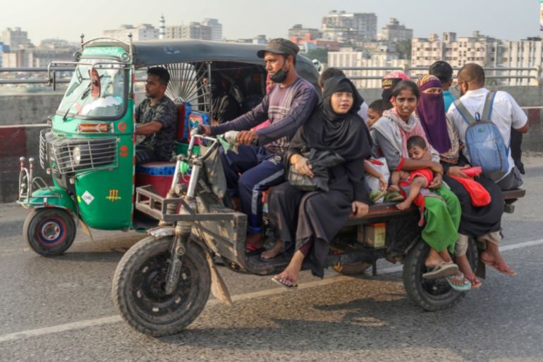 a family on a three wheeled motorcycle next to a tuk tuk