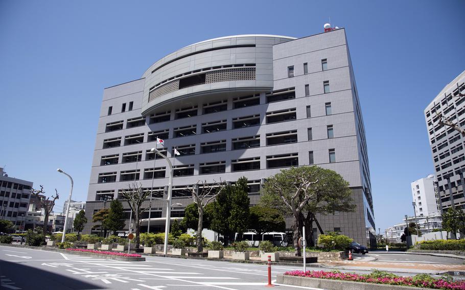 A large multi-story gray building with a Japanese flag out fromt. 