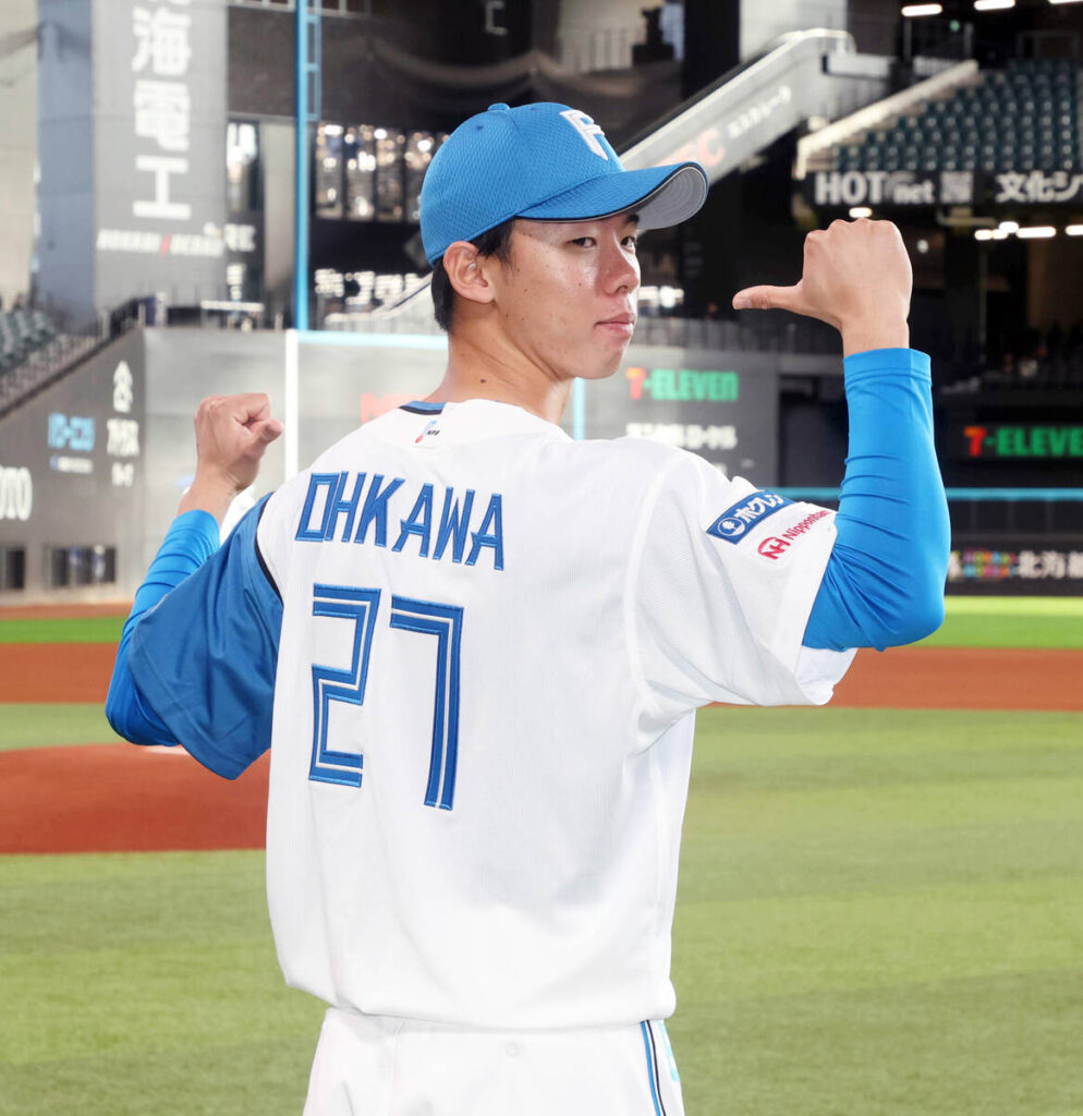 背番号「２７」のユニホームを披露する大川慈英（カメラ・池内　雅彦）