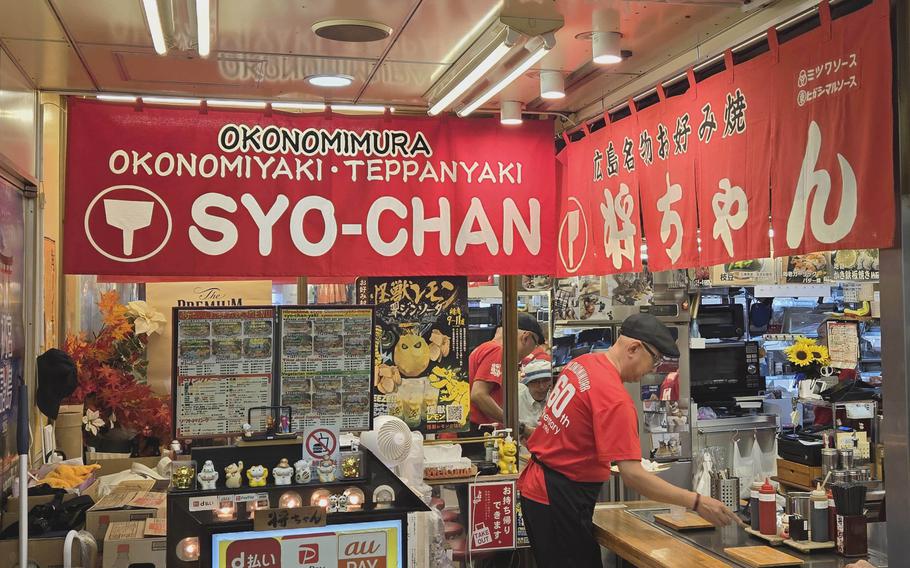 A cluttered market in Hiroshima, Japan, contains several okonomiyaki stands that use local ingredients.