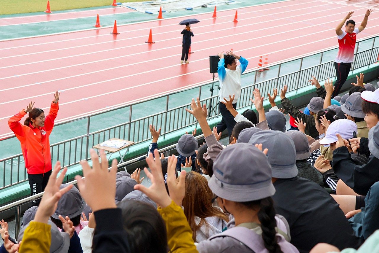 Schoolchildren practice “cheer signs” at a Deaflympics promotional event a month before the games. (© Matsumoto Sōichi, Nippon.com)