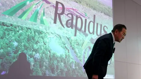 Getty Images Rapidus Corporation President Atsuyoshi Koike bows during a press conference in Tokyo