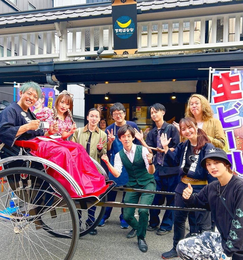 Arisa Sekimori, standing between the rickshaw handles, poses happily with some of her customers. Photo: IG@arisa _sekimori