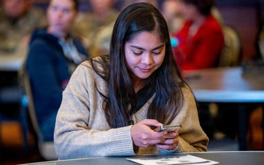U.S. Air Force 2nd Lt. Samantha Bostick, 35th Fighter Wing Public Affairs chief of media operations, scans a QR code during a 35th Fighter Wing (FW) Open Forum Town Hall event at Misawa Air Base, Japan, Nov. 19, 2025.