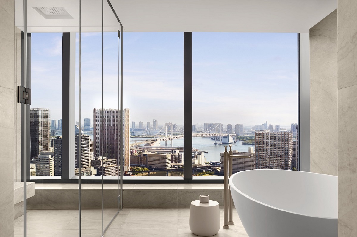 presidential bath suite with free standing bath in front of floor to ceiling windows with view over Tokyo