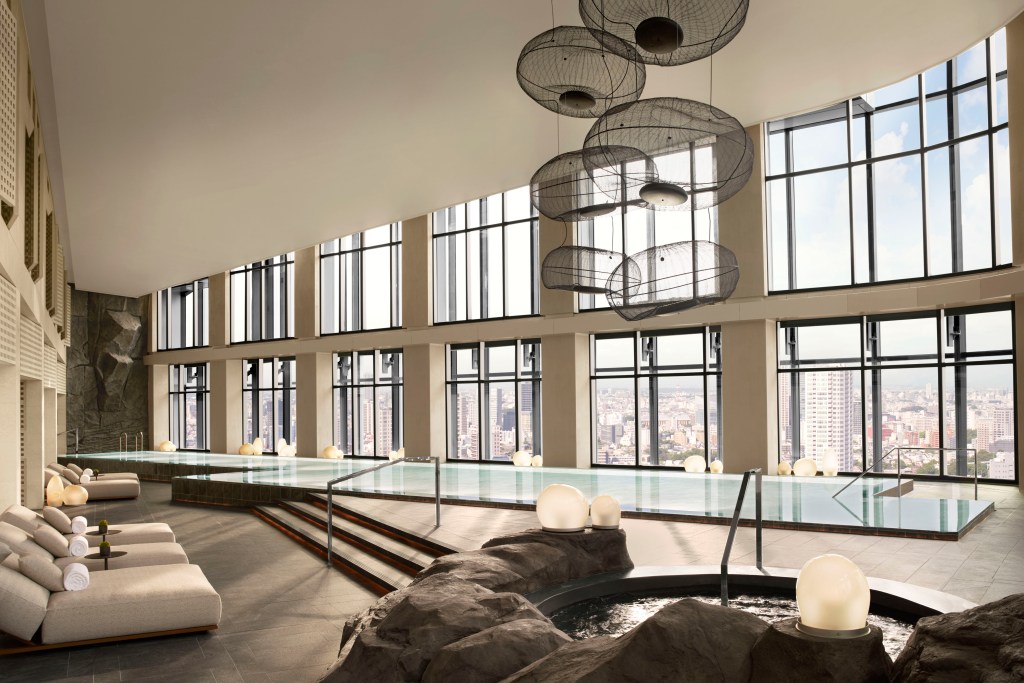 An indoor infinity pool with views of the city skyline at JW Marriott Tokyo.