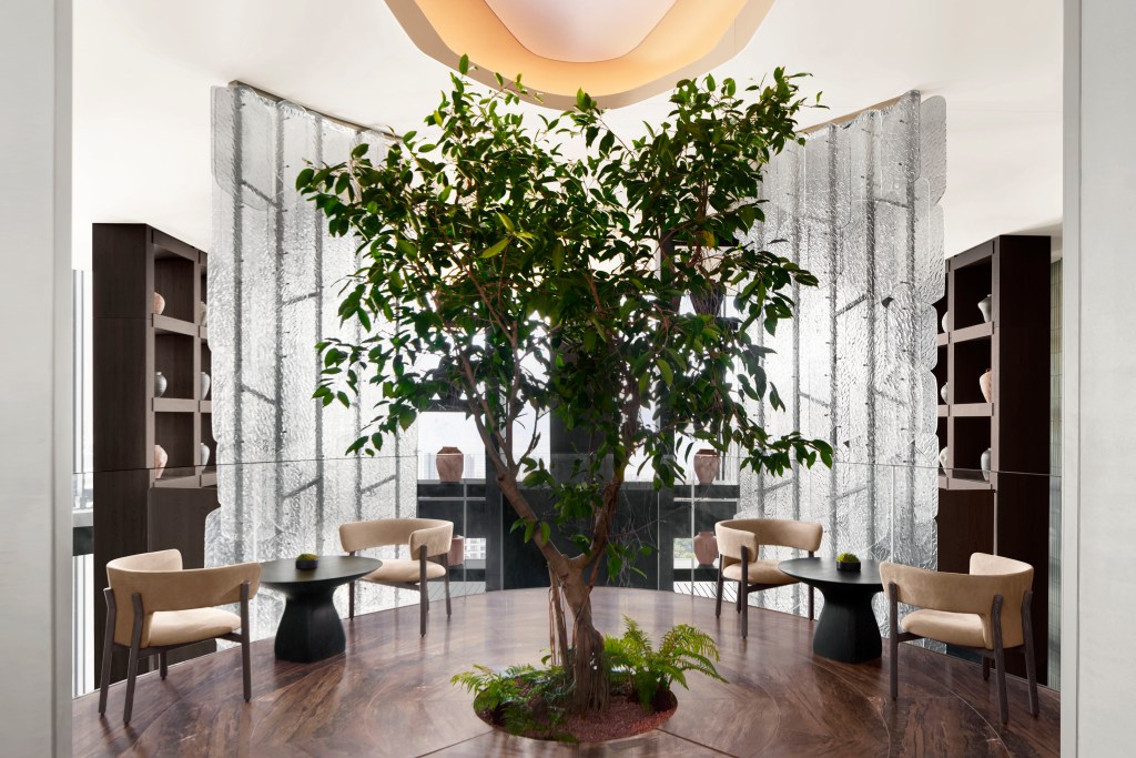 A grand room at the JW Marriott Tokyo with a tree in the middle of it.