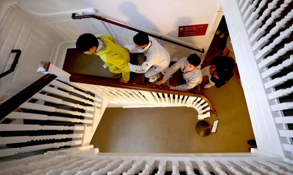 Nanae students Outa Kitamura, left, Joshin Kugita and Shogo Kimura ascend a staircase during a visit to the Concord Museum on Tuesday, October 28, 2025. Ken McGagh/The Concord Bridge