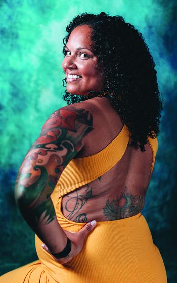 Tiffany Winston showing her tattoos on her left arm and back.