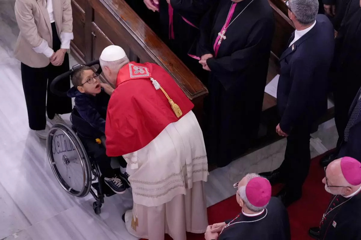 Pope Leo XIV greets a child as he meets the clergy at the Cathedral of the Holy Spirit, in Istanbul, Turkey, Friday, Nov. 28, 2025. (AP Photo/Domenico Stinellis)