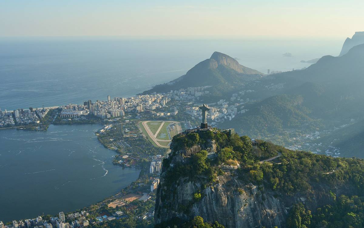 Ariel shot of Rio de Janeiro with Christ the Redeemer statue overlooking the city with the sea in the background