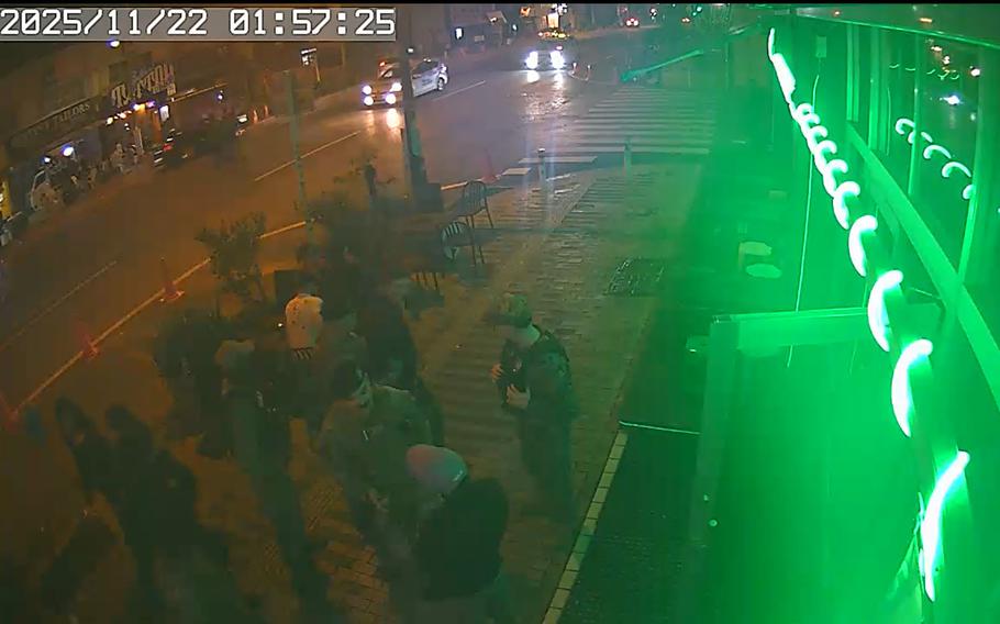 In this screenshot from a security video, Kareem El, second from right, speaks with a security forces airman outside of a bar.