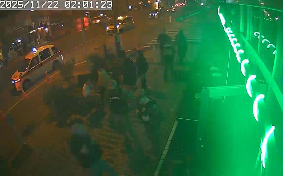 In this screenshot from security video, a security forces airman lifts Kareem El by the shoulders outside of a bar.